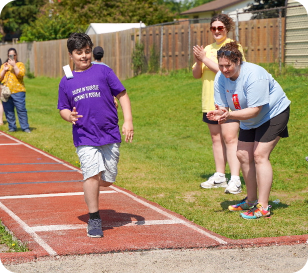 spectators on sidelines cheer on participant in long jump